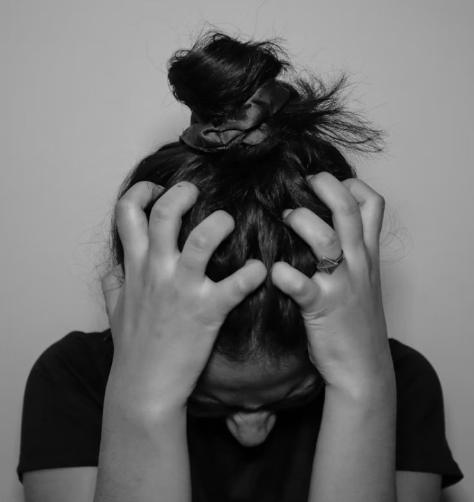 Teenage girl holding head in frustration