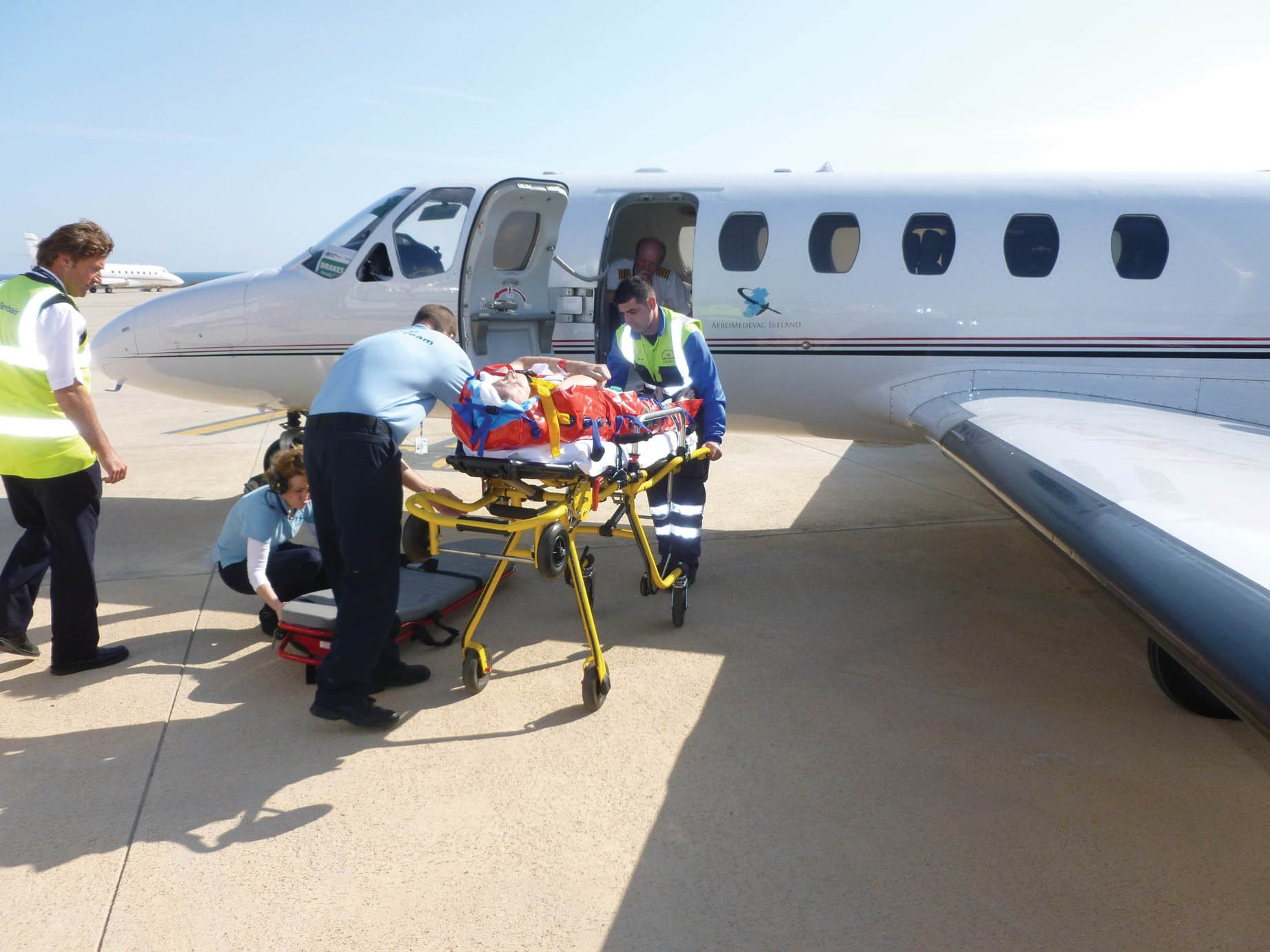 Air ambulance aircraft on a runway preparing patient for departure for emergency medical evacuation.
