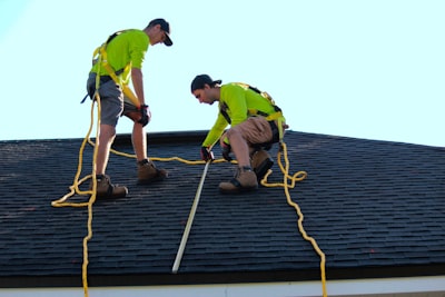 two roofers working on an asphalt shingle roof
