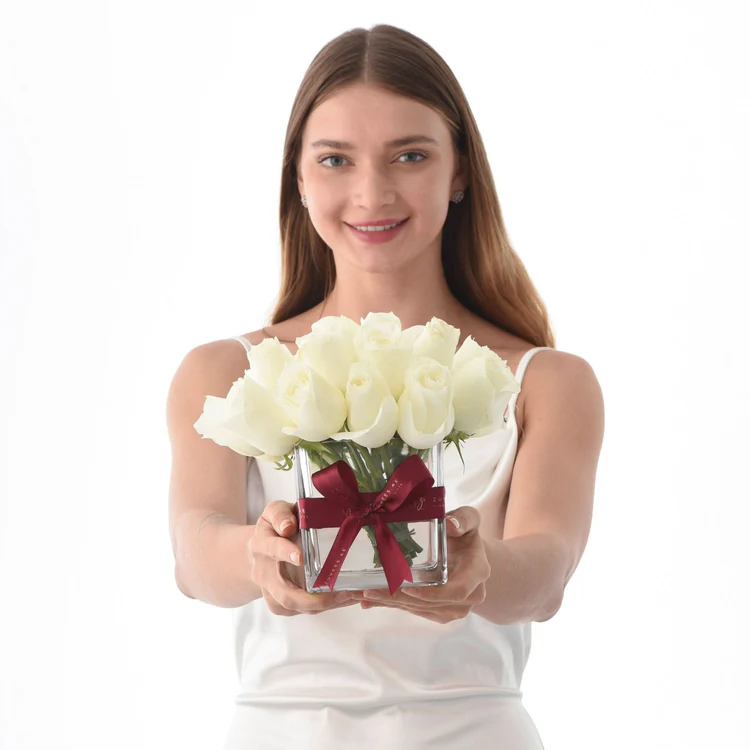 Lady holding a vase of white flowers