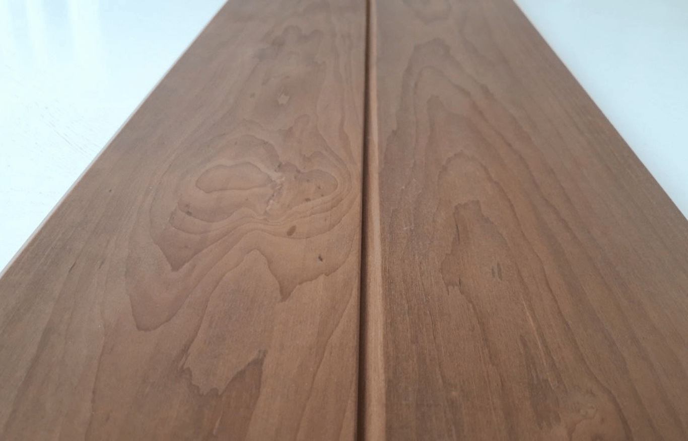 Close-up of thermally modified wood boards showing natural grain pattern, smooth surface, and rich brown tone.