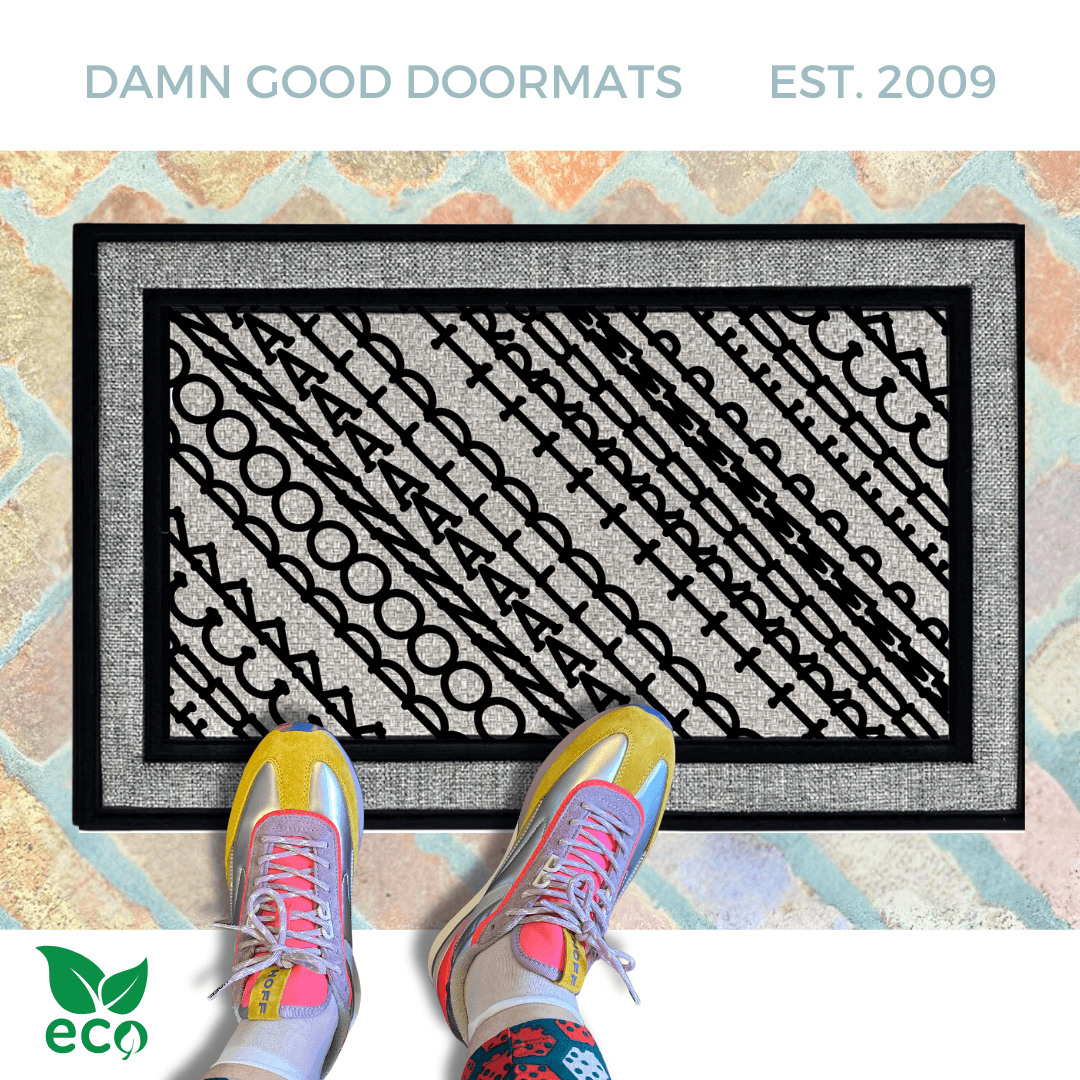 a pair of feet in colorful sneakers standing on an all weather doormat with a geometric Fuck Donald Trump pattern