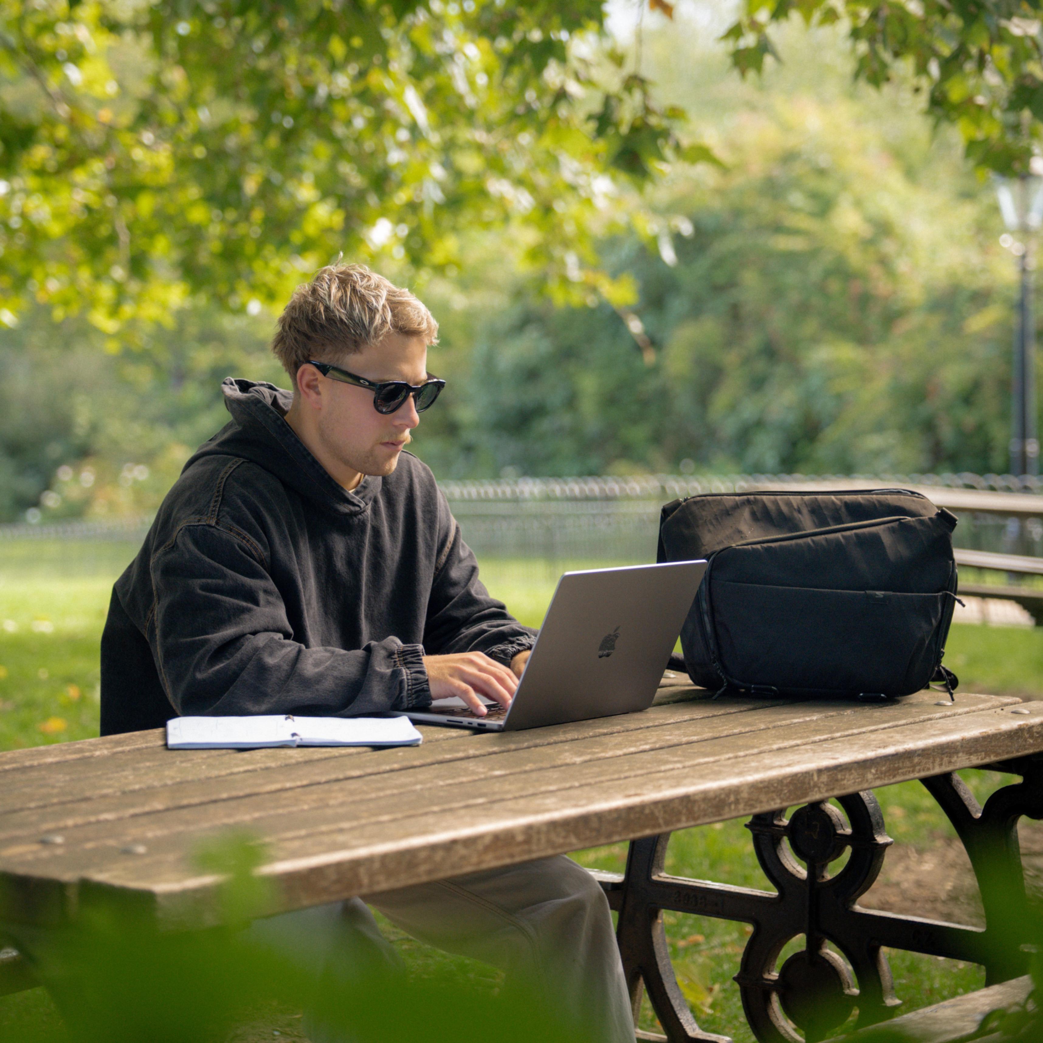 man using laptop outdoors