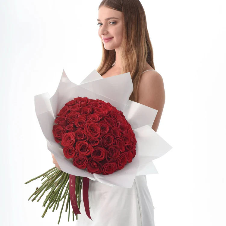 Lady holding bouquet of red flowers
