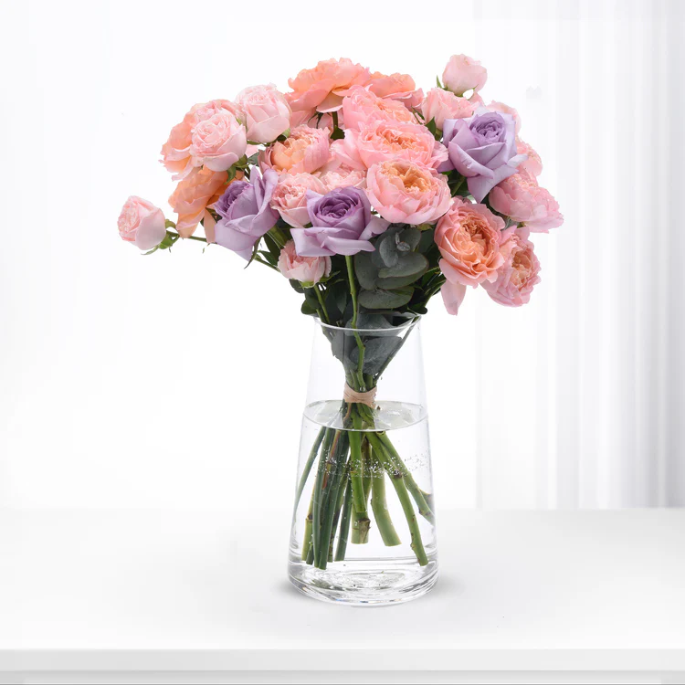Pink and purple flowers in glass vase