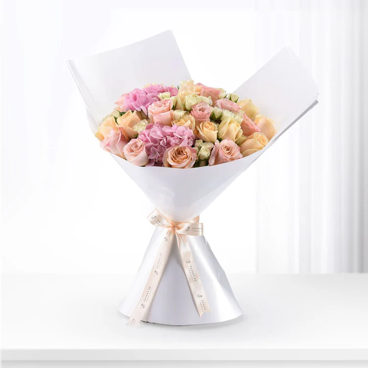 pink and yellow flowers wrapped in white paper