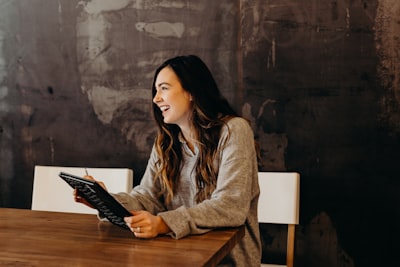 woman laughing over tablet
