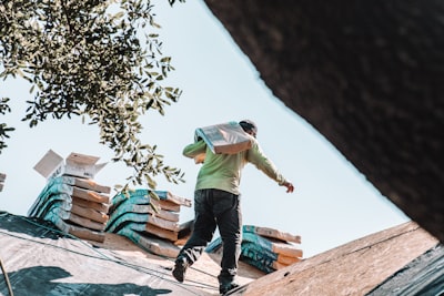  a roofer perparing to work on the first row of shingles